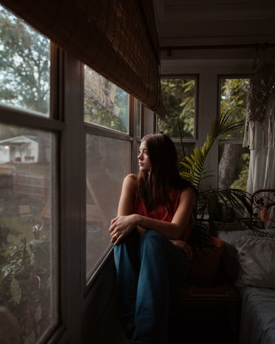 woman in blue denim jeans sitting on bed